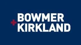Logo featuring the text "Bowmer + Kirkland" in bold white letters on a dark blue background, with a red plus sign between the two names.