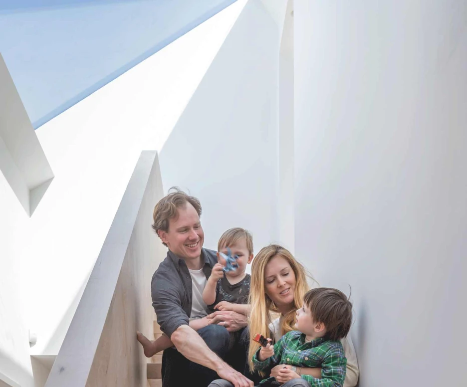 Family sat on stairs next to a Pitchglaze skylight.