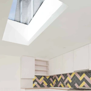 A modern kitchen featuring white cabinets, a colorful herringbone-patterned backsplash in shades of pink, yellow, and gray, and a skylight that lets in natural light.