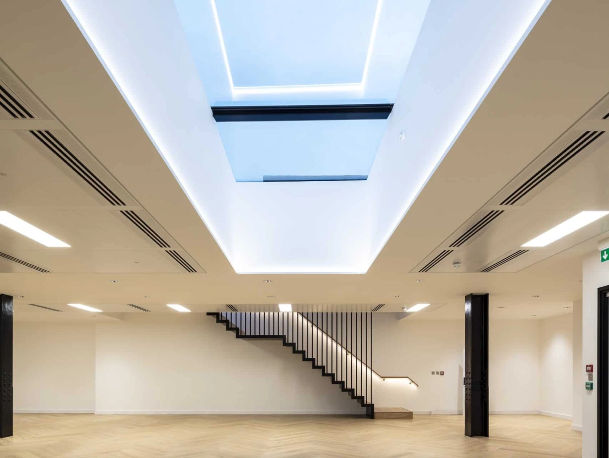 showing a staircase in a large empty room showing the skylight above