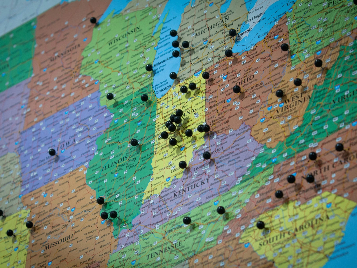 A colorful map of the eastern United States with several black pins marked in various locations.