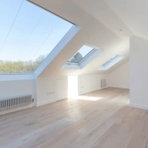 An empty room with white walls. To the left you can see 3 roof windows.