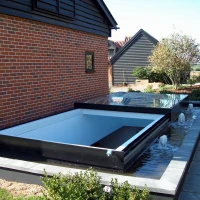 Un design contemporanee de jacuzzis es incorporat in un huerto. Le jacuzzi es partialmente coperte con un vitra. Fontanas de aqua es visible circum le jacuzzi, con un contorno de plantas e pavimento de piedra.