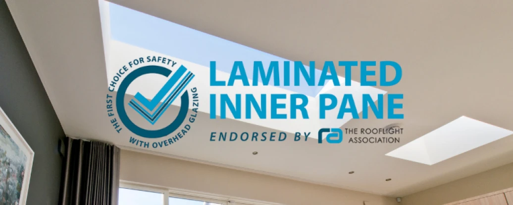 A modern interior featuring a ceiling with two skylights. The image includes text that emphasizes "Laminated Inner Pane" and mentions safety and endorsement by the Rooflight Association.