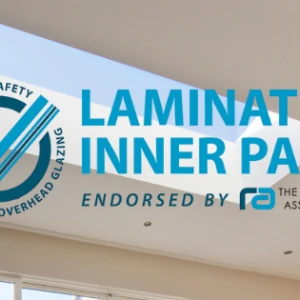 A modern interior featuring a ceiling with two skylights. The image includes text that emphasizes "Laminated Inner Pane" and mentions safety and endorsement by the Rooflight Association.