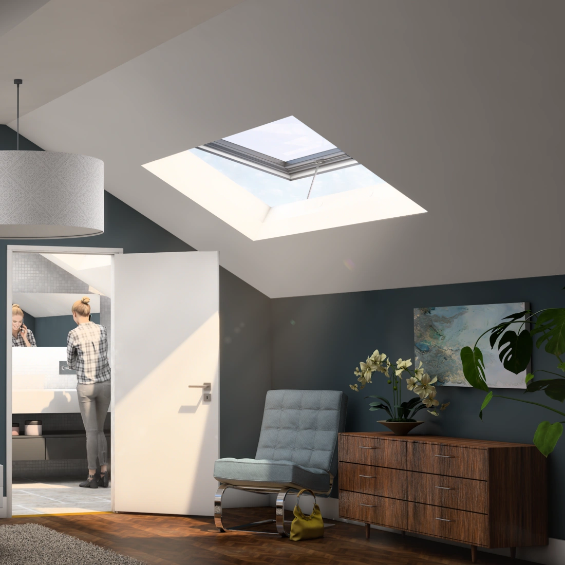 Bright and modern attic bedroom featuring a bed with white bedding, a stylish bedside lamp, and artwork on the walls. A woman is seen in the adjoining bathroom, while large skylights let in natural light. A wooden dresser and a contemporary chair complete the cozy atmosphere.